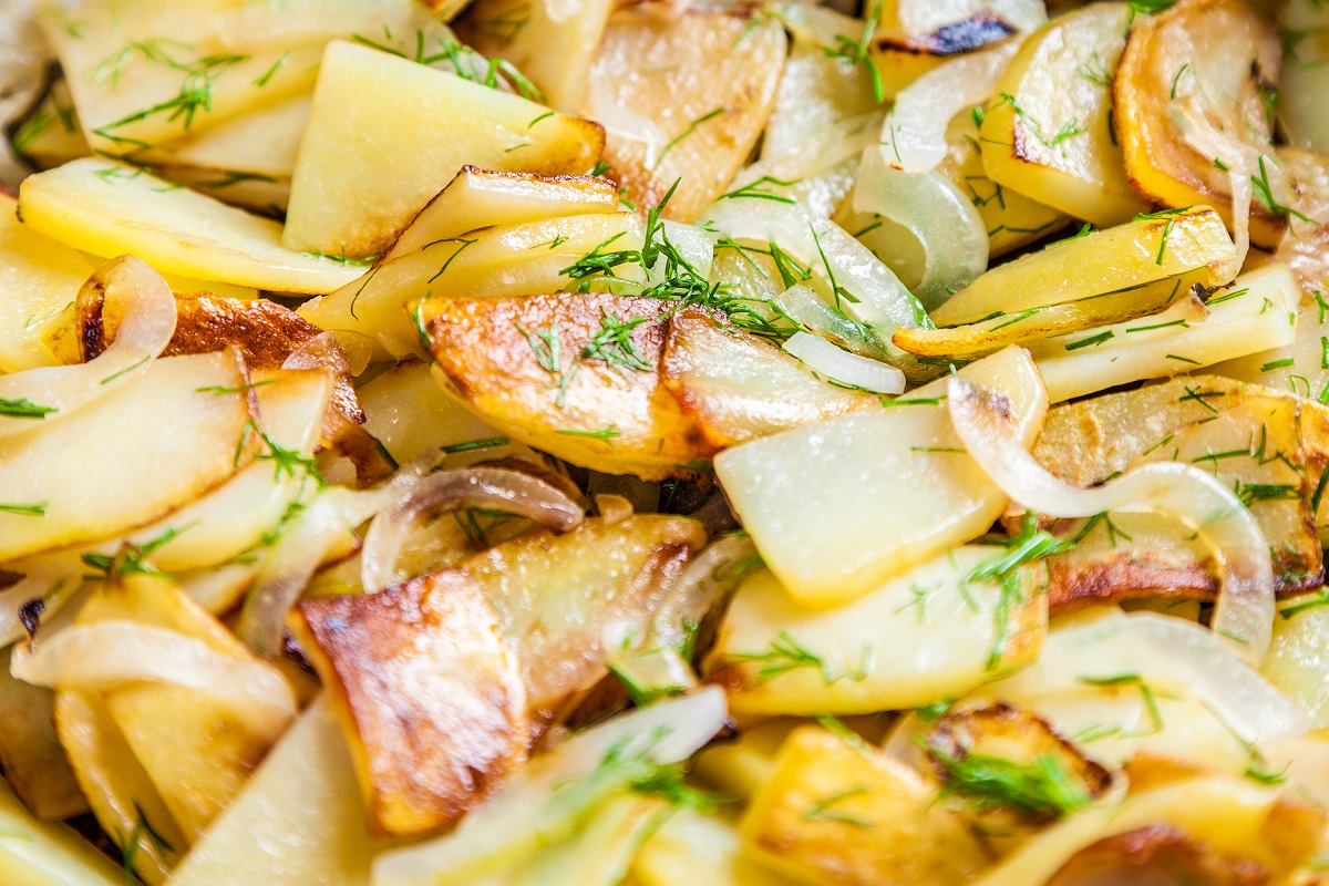 La ricetta delle patate al forno con cipolle, un contorno saporito e sfizioso
