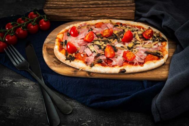 Pinsa piatto tipico romano con prosciutto pomodori e zucchine