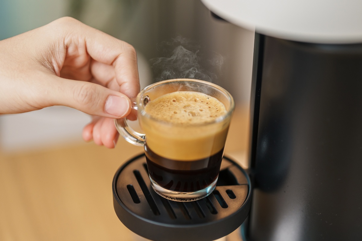 Caffè espresso fumante appena fatto con macchina da caffè.