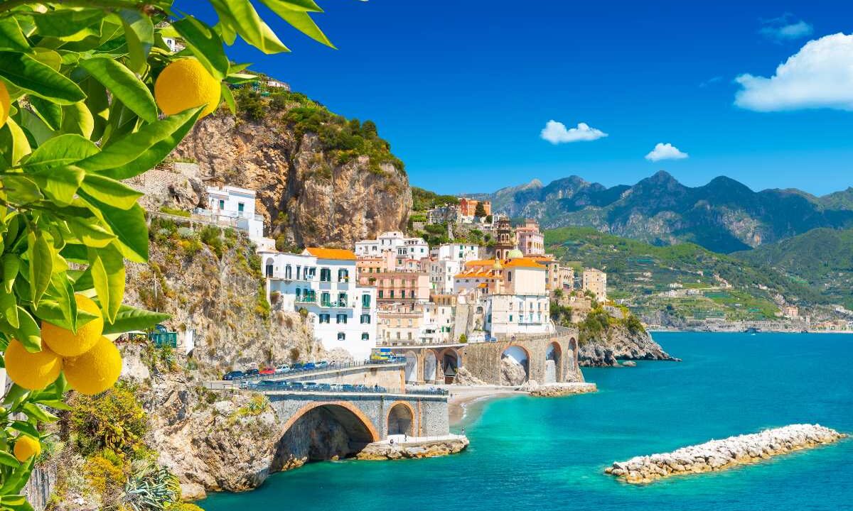Veduta di Amalfi in Campania con la città e il mare incorniciati da una pianta di limoni.
