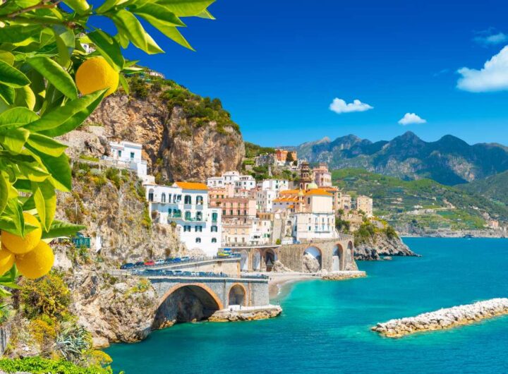 Veduta di Amalfi in Campania con la città e il mare incorniciati da una pianta di limoni.